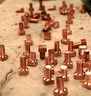 The unique custom square rivets being fabricated for solid copper bar.