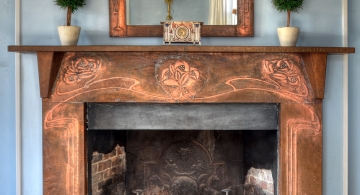 A near-reproduction of a copper fireplace surround originally designed by Walton. The Voysey wrought iron fire basket is also a near reproduction, as the structure has been modified for wood-burning in Sag Harbor instead of coal-burning in Glasgow or London. The clock and mirror are originals; probably Walton's.