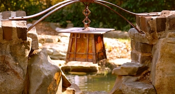 Copper lantern over a pond by Archive Designs