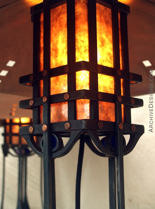 Table lamp in copper and steel with close up of glowing mica lamp cover