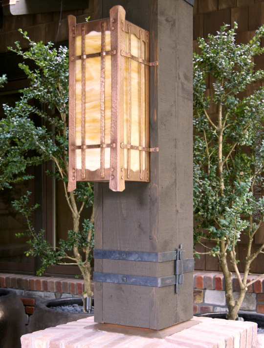 Post lantern in copper and art glass. Below it are forged steel straps to hold post together.