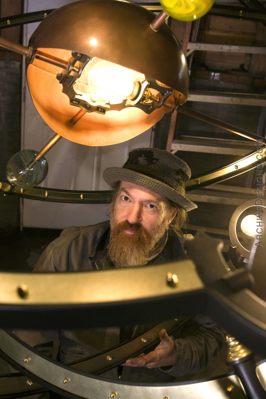 The designer, Joseph Mross, inside the oversized chandelier's rings