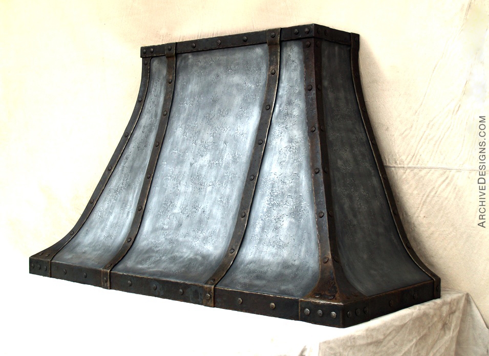 This distressed zinc and forged steel range hood was made for a 14th Century French country-inspired wine estate in Sonoma, California. We created several other items for this stunning home including a pot rack, fireplace doors, wrought iron brackets and truss tie rods, door straps, shelf and a copper door for a control box.